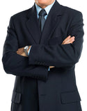 Man wearing a navy suit with arms crossed on a white background