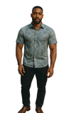 Man wearing a patterned short-sleeve shirt on a white background
