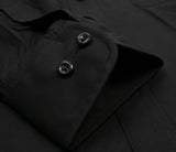 Close-up of a black long-sleeve shirt or jacket cuff with two dark buttons, showing the fabric texture and stitching.