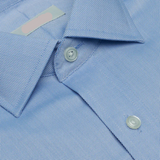 Close-up of a light blue checkered shirt with buttons and collar details.