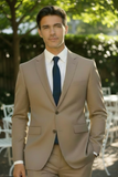 Man wearing a beige suit with a blue tie outdoors