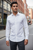 Man wearing a white dress shirt and dark pants on a city street.