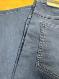 Close-up of a blue denim pocket with a brand label on a wooden surface