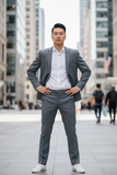 Man in a gray suit standing in an urban setting with blurred people in the background