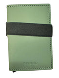 A green leather Secrid card holder wallet with a black elastic band closure, placed on a light wood surface.